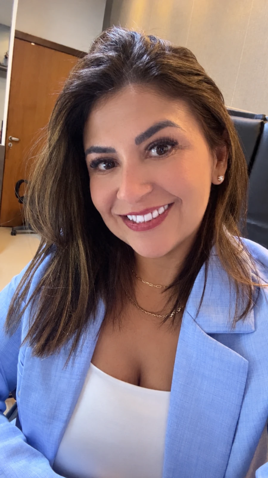 Dra. Gilveli Araújo, de blazer azul-claro, em seu escritório