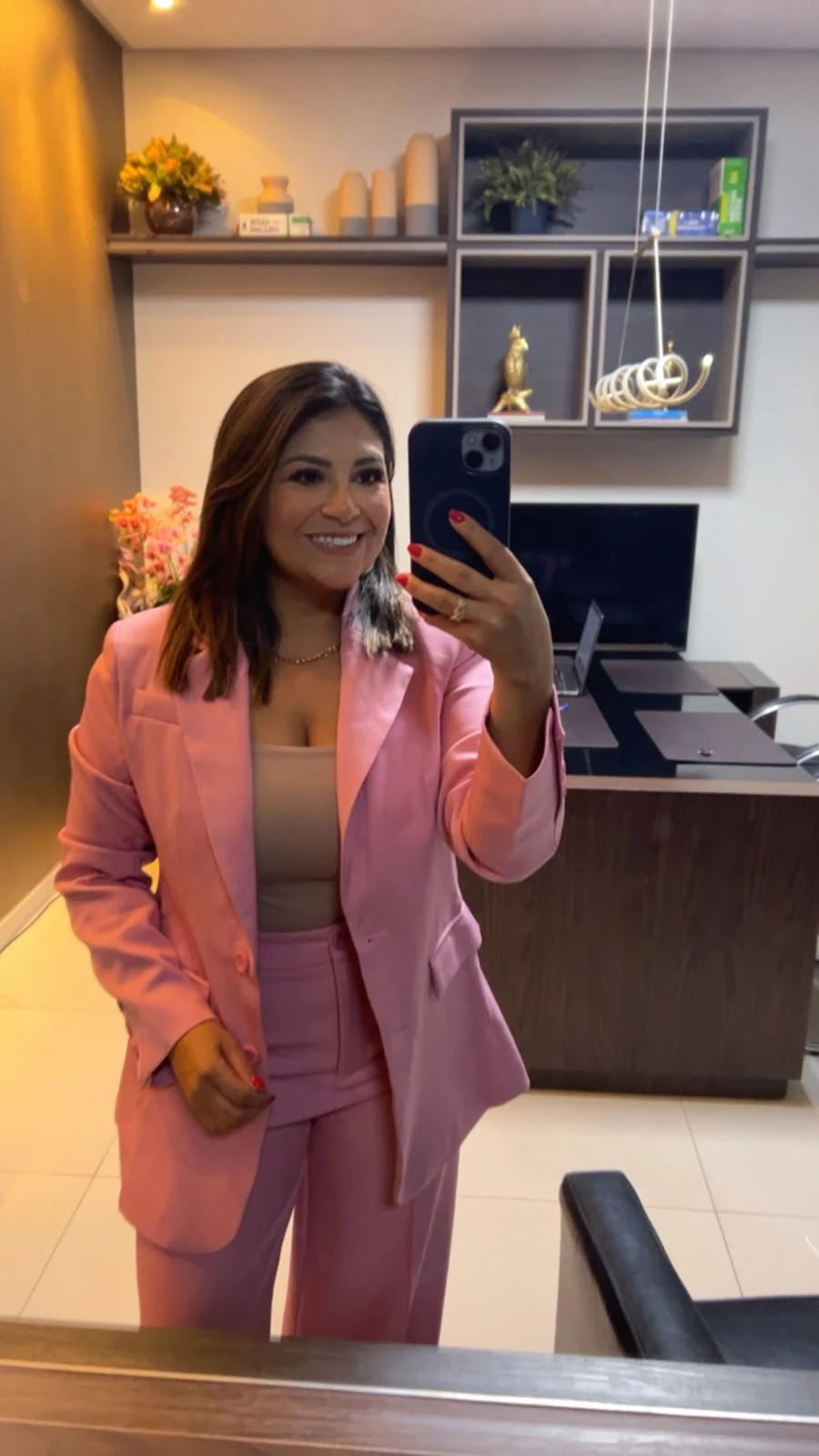 Dra. Gilveli Araújo, de blazer rosa, em seu escritório